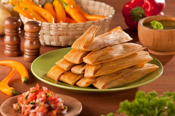 Piles of tamales on a table.